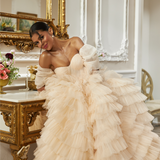 Off-shoulder ball gown - Sweetheart neckline wedding dress - Tiered tulle wedding gown - Ruffled layers bridal dress - Lace and bead detailing bridal gown - Dramatic train wedding dress - Blush and ivory wedding dress - Structured corset bridal gown - Elegant wedding dress - Romantic off-shoulder gown