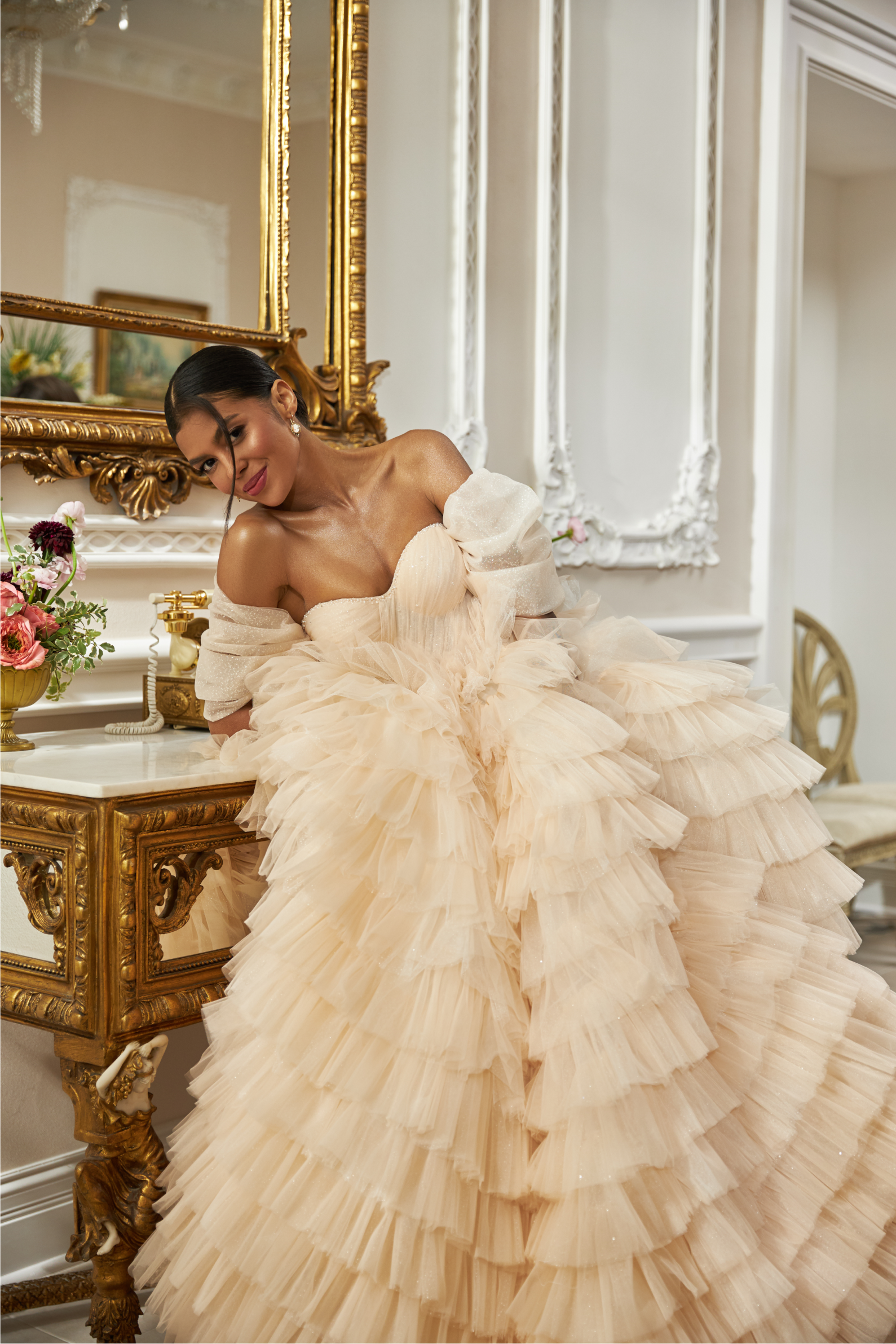 Off-shoulder ball gown - Sweetheart neckline wedding dress - Tiered tulle wedding gown - Ruffled layers bridal dress - Lace and bead detailing bridal gown - Dramatic train wedding dress - Blush and ivory wedding dress - Structured corset bridal gown - Elegant wedding dress - Romantic off-shoulder gown