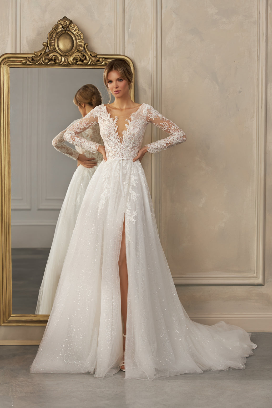 Long-sleeve A-line gown - Plunging neckline bridal dress - Floral lace appliqué dress - Sheer lace sleeves - Fitted bodice - Flowing skirt with high slit - Elegant wedding dress - Formal bridal gown - Modern sophisticated dress - Timeless beauty gown
