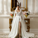 High-low gown - Sweetheart neckline bridal dress - Floral lace appliqué dress - Sparkling beadwork dress - Open-front skirt - Embellished underlay - Elegant wedding dress - Formal bridal gown - Modern sophisticated dress - Unique wedding attire