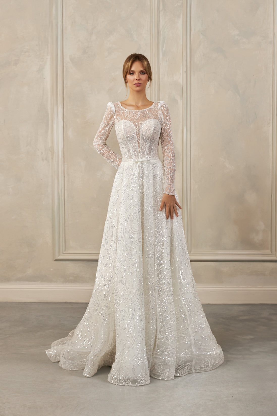 Long-sleeve A-line gown - Illusion neckline bridal dress - Sheer beaded sleeves - Sweetheart underlay bodice - Intricate beadwork dress - Flowing A-line skirt - Elegant wedding dress - Formal bridal gown - Sophisticated wedding attire - Timeless beauty gown