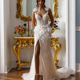 Sleeveless sheath gown - Plunging neckline bridal dress - Floral appliqué dress - Shoulder embellishments - Fitted bodice with lace - Sheer skirt with high slit - Elegant wedding dress - Formal bridal gown - Modern sophisticated dress - Timeless beauty gown