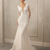Long-sleeve mermaid gown - Deep V-neck bridal dress - Sheer illusion sleeves - Floral lace appliqué dress - Fitted bodice with lace - Mermaid silhouette with train - Elegant wedding dress - Formal bridal gown - Sophisticated wedding attire - Timeless beauty gown