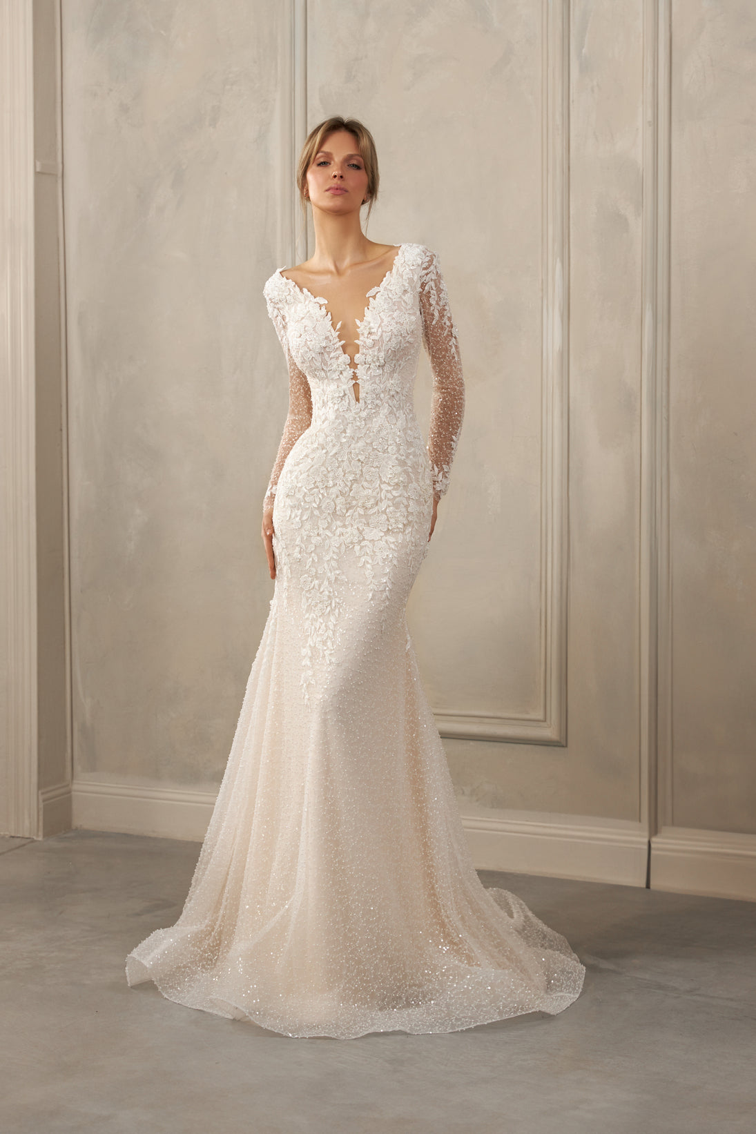 Long-sleeve mermaid gown - Deep V-neck bridal dress - Sheer illusion sleeves - Floral lace appliqué dress - Fitted bodice with lace - Mermaid silhouette with train - Elegant wedding dress - Formal bridal gown - Sophisticated wedding attire - Timeless beauty gown