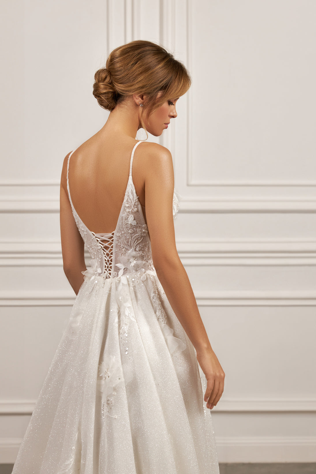 Sleeveless A-line gown - Plunging neckline bridal dress - Floral appliqué dress - Spaghetti strap wedding gown - Fitted bodice with lace - Shimmering A-line skirt - Elegant wedding dress - Formal bridal gown - Contemporary style dress - Classic elegance gown