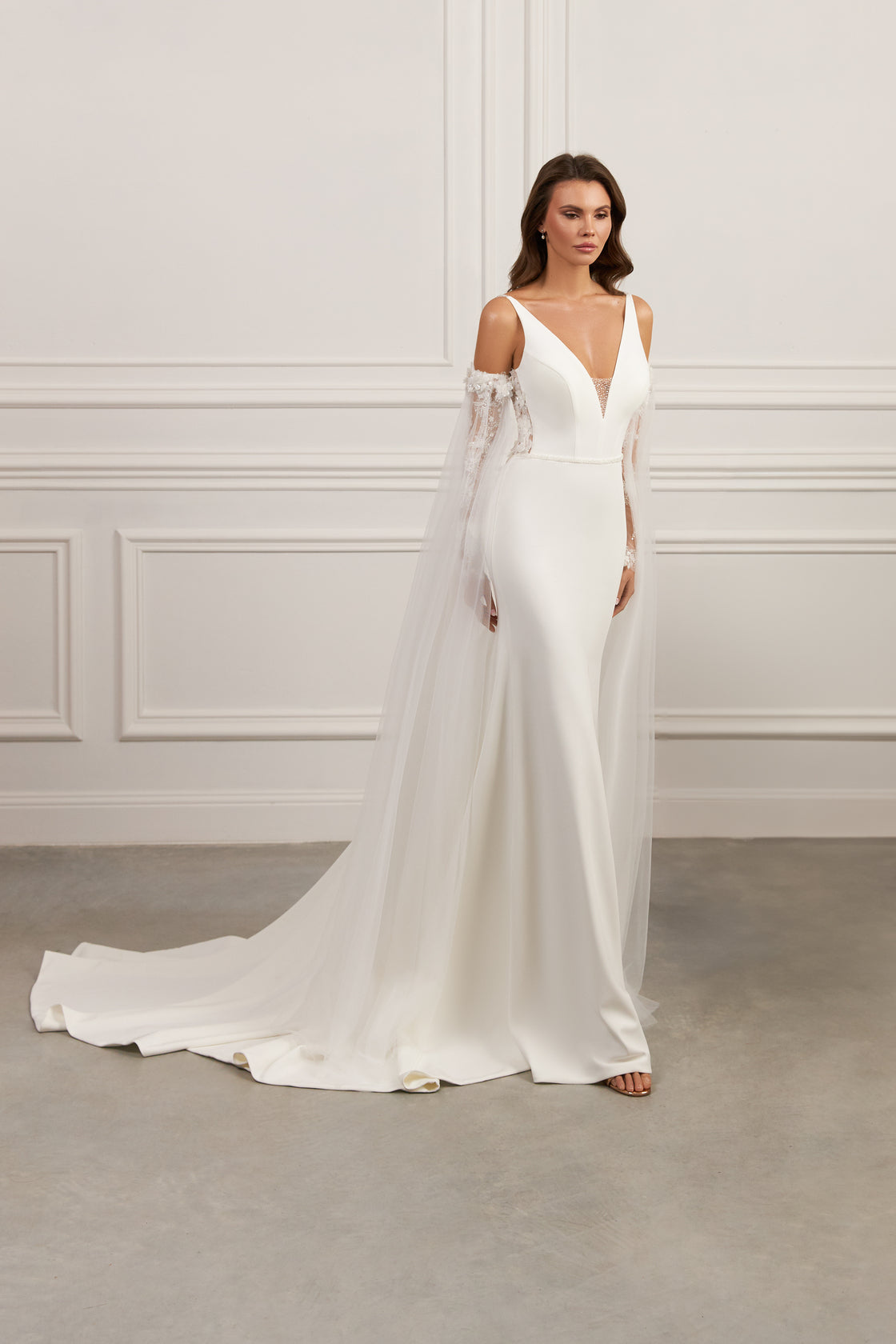 Off-the-shoulder wedding gown - Deep V-neck bridal dress - Long sleeve lace dress - Fitted bodice wedding gown - Flowing skirt with train - Elegant wedding dress - Formal bridal gown - Sophisticated wedding attire - Modern bride dress - Regal wedding dress